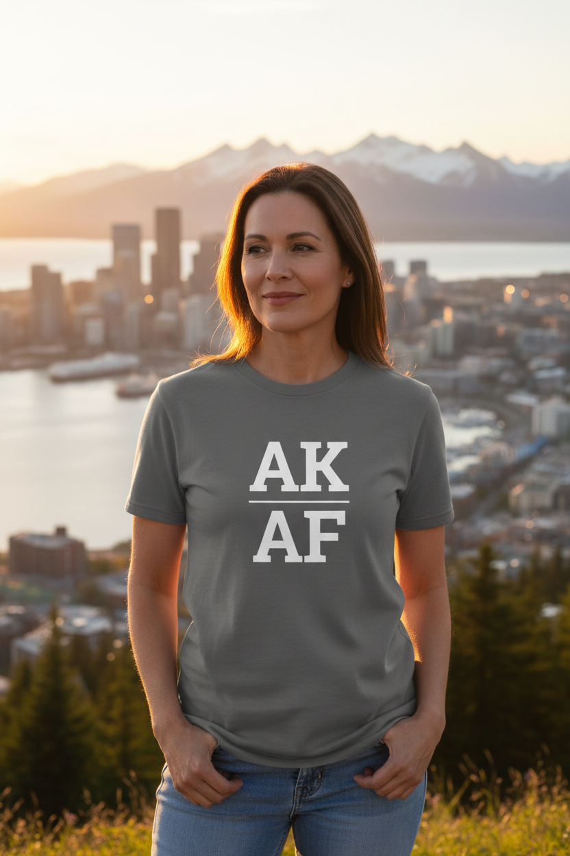 Person wearing grey Alaska t-shirt with Anchorage skyline backdrop
